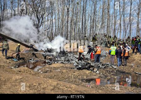 Budgam, au Cachemire. 27 Février, 2019. Inspecter les sauveteurs l'épave d'un avion militaire indien qui s'est écrasé à Budgam, à 20 km de Srinagar, au Cachemire. Une armée de l'air indienne s'est écrasé mercredi dans le district de Budgam du Cachemire, tuant sept personnes dont six membres du personnel de la Force aérienne indienne et l'autre civile. L'avion s'est écrasé pour des raisons techniques, selon les responsables. Credit : Saqib Majeed/SOPA Images/ZUMA/Alamy Fil Live News Banque D'Images