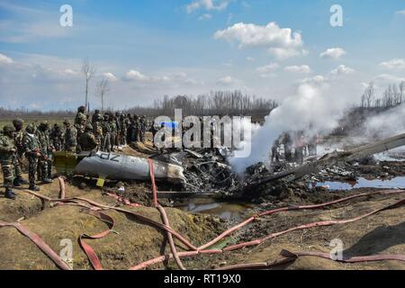 Budgam, au Cachemire. 27 Février, 2019. Les soldats de l'armée indienne se rassemblent autour de l'incendie d'un avion militaire indien qui s'est écrasé à Budgam, à 20 km de Srinagar, au Cachemire. Une armée de l'air indienne s'est écrasé mercredi dans le district de Budgam du Cachemire, tuant sept personnes dont six membres du personnel de la Force aérienne indienne et l'autre civile. L'avion s'est écrasé pour des raisons techniques, selon les responsables. Credit : Saqib Majeed/SOPA Images/ZUMA/Alamy Fil Live News Banque D'Images