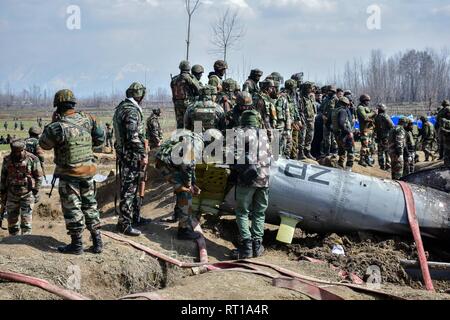 Budgam, au Cachemire. 27 Février, 2019. Les hommes de l'armée indienne inspecter l'épave d'un avion militaire indien qui s'est écrasé à Budgam, à 20 km de Srinagar, au Cachemire. Une armée de l'air indienne s'est écrasé mercredi dans le district de Budgam du Cachemire, tuant sept personnes dont six membres du personnel de la Force aérienne indienne et l'autre civile. L'avion s'est écrasé pour des raisons techniques, selon les responsables. Credit : Saqib Majeed/SOPA Images/ZUMA/Alamy Fil Live News Banque D'Images