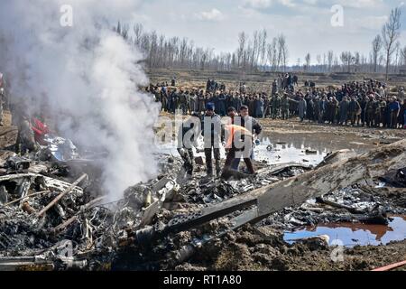 Budgam, au Cachemire. 27 Février, 2019. Inspecter les sauveteurs l'épave d'un avion militaire indien qui s'est écrasé à Budgam, à 20 km de Srinagar, au Cachemire. Une armée de l'air indienne s'est écrasé mercredi dans le district de Budgam du Cachemire, tuant sept personnes dont six membres du personnel de la Force aérienne indienne et l'autre civile. L'avion s'est écrasé pour des raisons techniques, selon les responsables. Credit : Saqib Majeed/SOPA Images/ZUMA/Alamy Fil Live News Banque D'Images