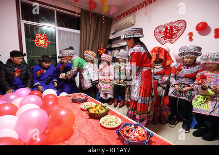 (190227) -- WENZHI LANE, le 27 février 2019 (Xinhua) -- mariée Han Yujie(Le port de voile) et les membres de sa famille et parents(tous assis) obtenir assisté dans la maison du fiancé dans Wenzhi Lane County, au sud-ouest de la province chinoise du Sichuan, le 26 février 2019. Yang Yuqiao et Han Yujie, de l'ethnie Miao, couple, attaché le noeud dans un style traditionnel Miao dans Wenxing, au sud-ouest du comté de la province chinoise du Sichuan, du 24 au 26 février 2019. Yang Yuqiao, le marié de 25 ans, travaille comme guide touristique dans le géoparc mondial UNESCO Wenzhi Lane, et Han Yujie, l'épouse de 23 ans, travaille comme professeur dans le canton de Miao Dahe Wenzhi Lane Comté. Au cours de th Banque D'Images