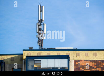 25 février 2019, Mecklembourg-Poméranie-Occidentale, Rostock : un mât avec plusieurs antennes des fournisseurs de téléphonie mobile se dresse sur un immeuble préfabriqué dans le district de Dierkow. Photo : Jens Büttner/dpa-Zentralbild/ZB Banque D'Images