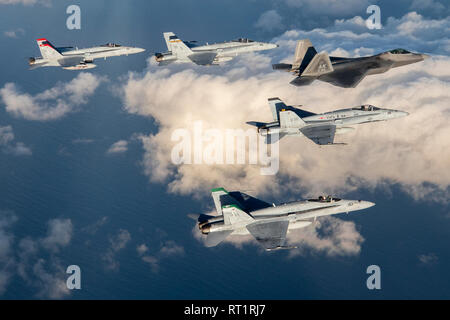 Quatre F/A-18 de la Marine Aircraft Group (MAG) 11, 3rd Marine Aircraft Wing (MAW), voler en formation serrée sur la côte sud de la Californie avec deux F-22 Raptors à partir de la 3e Groupe d'opérations, la base aérienne Elmendorf, en Alaska, le 6 février. Le vol a commémoré la formation conjointe des exercices réalisés au cours de l'hiver 2019 et Fury Grizzly Patriot 2019, qui était axée sur les grandes tactiques de la force de l'intégration de l'air haut de gamme simulé contre air-air et sol-air, d'autres menaces de l'Armée de l'air et Marine honage 4e et 5e génération de tactique et l'interopérabilité. Banque D'Images