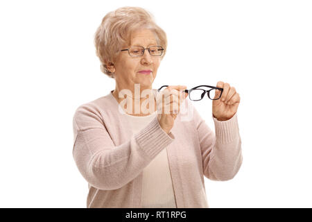 Senior woman holding une paire de nouvelles lunettes pour la vue et à les regarder isolé sur fond blanc Banque D'Images