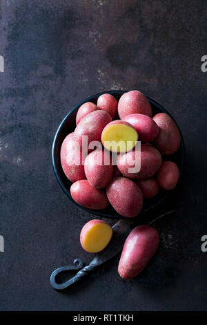 Pommes de terre grelots rouges sur métal rouillé Banque D'Images