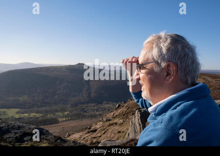 Man 60, ses yeux d'ombre d'un soleil éclatant à la recherche sur le paysage d'hiver en milieu rural en UK Banque D'Images