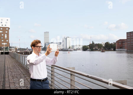 Allemagne, Berlin, businessman taking photo with digital tablet Banque D'Images