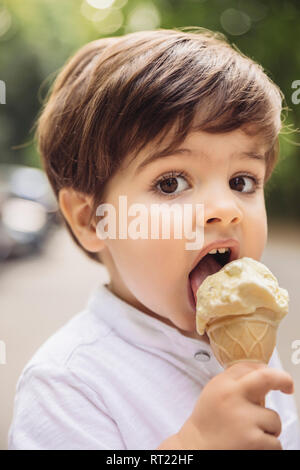 Portrait d'enfant en mangeant une glace à la vanille dans park Banque D'Images