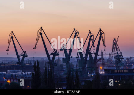 Gdansk, Pologne. Silhouettes de grues de port au coucher du soleil Banque D'Images