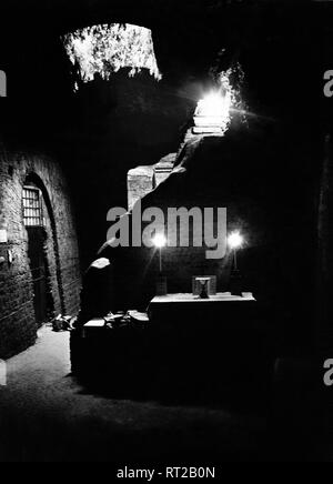 Erich Andres Italien - catacombes à Rome, une salle pour banquets funéraires, 1950. Photo par Erich Erich Andres Andres - Italie, Italia, Roma, Rome, histoire, historique, 1950, les Catacombes Italien - Triklinium der Trauer - Liebesmäler in den Katakomben en Rom in den 1950er Jahren. In diesem Raum und nach der Beerdigung eines Verstorbenen die üblichen Trauer-Liebesmäler abgehalten. 156 vorn im Halbdunkel Tuffstein-Bank ist noch die lange zu sehen, vor der der Tisch beladene üppig stand. Von hier führt eine Treppe, die heute ist verschlossen, dans die Oberwelt. Hier Stand der Eingang zur den City East Banque D'Images