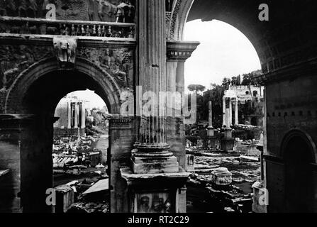 Erich Andres Italien - Das Forum Romanum im Rom der 1950er Jahre : Nordseite Ostseite und durch den Severus Bogen, liens die Porta Antonius und der Tempel Faustinus, rechts Portal des Castor Tempel und die Basilique Julia. 499/6 Banque D'Images