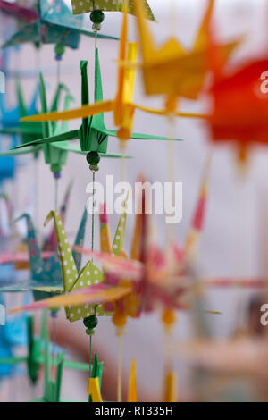 Plusieurs cygnes de couleurs décoratives faites en papier. Origami coloré du Japon. Papier pliée en forme d'animaux. Quelques silhouettes floues. Point mort Banque D'Images