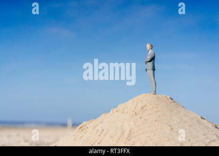 Figurine homme debout sur la colline de sable looking at view Banque D'Images