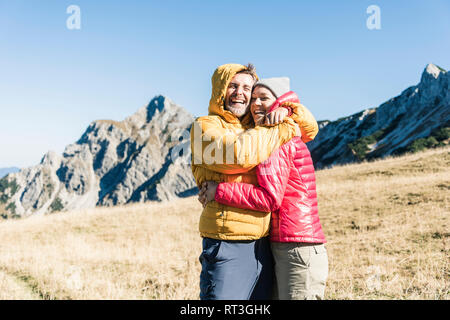L'Autriche, le Tyrol, l'heureux couple hugging en randonnée dans les montagnes Banque D'Images