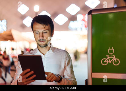 Businessman using digital tablet à côté de la station de charge Banque D'Images