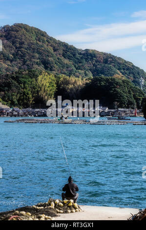 Le Japon, Kyoto Prefecture, village de pêcheurs Ine, paysage urbain avec angler Banque D'Images