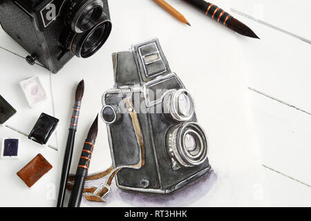 Aquarelle de caméra rétro, vintage photo, caméra de pinceaux et peintures à l'aquarelle. Mise à plat, vue du dessus. Banque D'Images