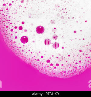 Mousse de savon avec bulles lumineuses sur fond violet. Sud du savon dans l'eau. Mise à plat. Banque D'Images