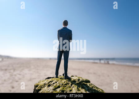 Figurine homme debout sur la colline de sable looking at view Banque D'Images