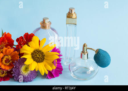 Flacons de parfum avec les fleurs colorées Banque D'Images