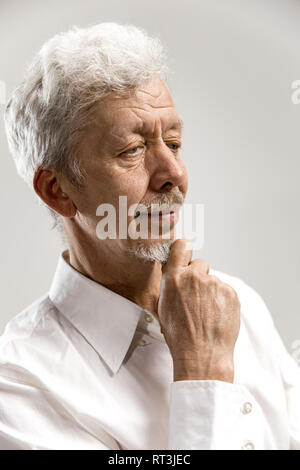 Serious businessman isolé sur fond studio gris. La moitié des hommes portrait en pied. Les émotions humaines, l'expression faciale concept Banque D'Images