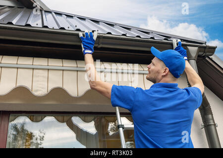 L'installation de l'homme système gouttière de toit de la chambre Banque D'Images