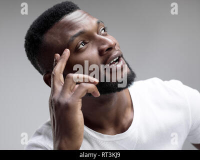 Se souvenir de tout. Permettez-moi de penser. Doute concept. Douteux, réfléchie homme africain de se rappeler quelque chose. Les émotions humaines, l'expression faciale concept. Studio. Banque D'Images