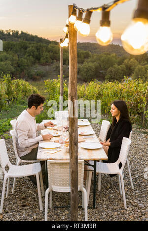 Italie, Toscane, Sienne, jeune couple en train de dîner dans un vignoble Banque D'Images