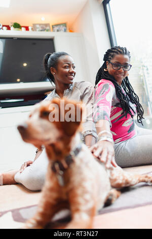 Mère et sa fille adulte avec chien sur plancher du salon Banque D'Images