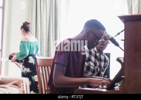 Les frère et sœur à jouer du piano et chant Banque D'Images