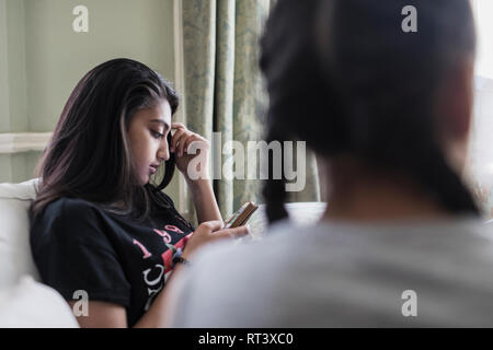 Le Tween girl texting with smart phone Banque D'Images