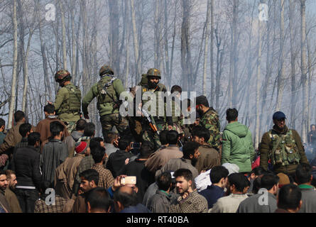 Budgam, au Cachemire. Feb 27, 2019. Kashmirn les hommes de l'armée de se tenir près de l'emplacement de l'accident dans le centre du Cachemire Budgam le 27 février 2019. 6 membres du personnel à bord et un civil ont été tués lorsque l'armée s'est écrasé dans un champ près du village de Budgam Garend Kalaan district de Jammu-et-Cachemire au milieu des tensions frontalières avec le Pakistan. Credit : Umer Asif/Pacific Press/Alamy Live News Banque D'Images