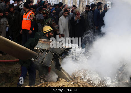 Budgam, au Cachemire. Feb 27, 2019. Membre de l'incendie et d'urgence éteindre les flammes dans le centre du Cachemire Budgam le 27 février 2019. 6 membres du personnel à bord et un civil ont été tués lorsque l'armée s'est écrasé dans un champ près du village de Budgam Garend Kalaan district de Jammu-et-Cachemire au milieu des tensions frontalières avec le Pakistan. Credit : Umer Asif/Pacific Press/Alamy Live News Banque D'Images