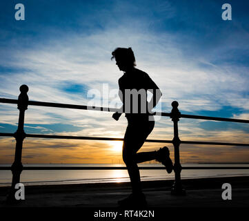 Femme jogging au lever du soleil. Banque D'Images
