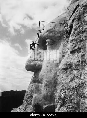 Gutzon Borglum inspecter le travail sur le visage du Président Washington, Mt. Rushmore, dans le Dakota du Sud. Banque D'Images