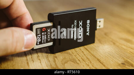PARIS, FRANCE - MAR 26, 2017 : l'homme insère de nouvelles données XQD fabriqué par Sony carte mémoire utilisée dans Nikon et Sony video photo produits pour le stockage de contenus haut débit en USB Lecteur de carte XQD Banque D'Images