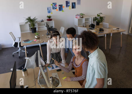 Des collègues de discuter sur ordinateur de bureau en Banque D'Images
