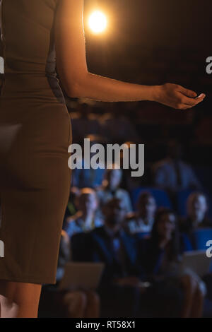 Businesswoman giving presentation in front of audience in auditorium Banque D'Images