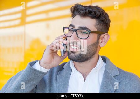 Portrait de jeune homme barbu au téléphone Banque D'Images