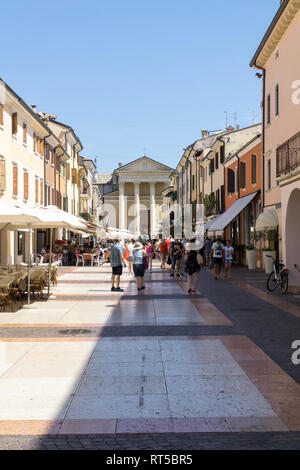 BARDOLINO, Vénétie, Italie - 7 août 2017 : Les gens de la rue principale du village de Bardolino en face de l'église paroissiale. Banque D'Images