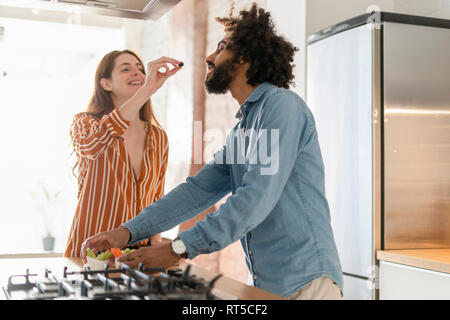 Couple dans la cuisine, à préparer le dîner, Woman feeding man d'oliviers Banque D'Images