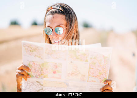 Jeune femme blonde portant des lunettes en miroir avec l'orientation de la carte Banque D'Images