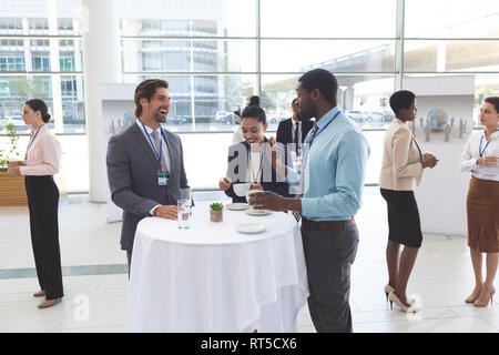 Les gens d'affaires en interaction les uns avec les autres à la table lors d'un séminaire Banque D'Images