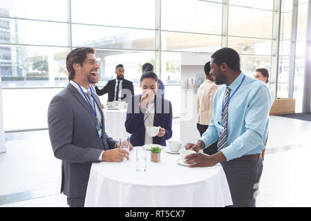 Les gens d'affaires en interaction les uns avec les autres à la table lors d'un séminaire Banque D'Images