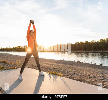 Jeune femme avec un kettlebell à la rivière Banque D'Images