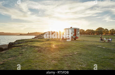 Le Chili, Santiago, Rio Maule, camping-au lac avec la famille en train de dîner au coucher du soleil Banque D'Images