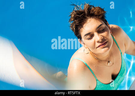 Portrait of young woman relaxing in swimming pool Banque D'Images