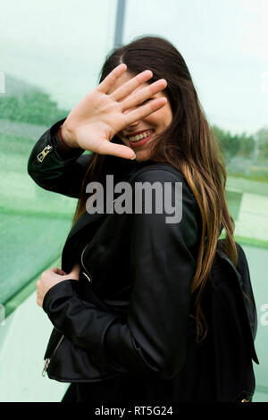Happy young woman couvrant son visage avec sa main Banque D'Images