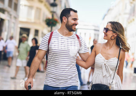 Espagne, Andalousie, Malaga, happy tourist couple marcher dans la ville Banque D'Images