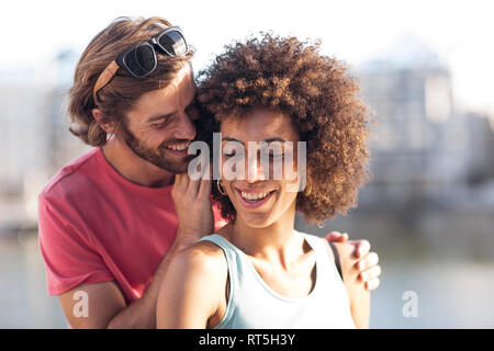 Happy young couple homme femme, chuchotant à l'oreille Banque D'Images